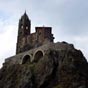 La chapelle Saint-Michel d'Aiguilhe est un bijou d'architecture. Construite au sommet d'un rocher volcanique de 82 mètres de haut, on y accède au bout d’un cheminement d’accès comportant 268 marches (comptez une dizaine de minutes environ). Au Xe siècle, Godescalc, l'évêque du Puy, fit ériger la chapelle dédiée à saint Michel au retour d'un pèlerinage à Saint-Jacques-de-Compostelle, pour accomplir un vœu. Inaugurée en 972, elle consistait, à l'origine, en une chapelle quadrangulaire dotée de trois absidioles. Au milieu du XIe siècle, l'édifice fut agrandi par l'ajout à l'ouest d’un clocher, inspiré de celui de la cathédrale du Puy, et d'une nef. Plus tard enfin, à la fin du XIe siècle, l'absidiole sud fut démolie pour, d'une part, faire place à une construction à l'usage du prêtre desservant, et d'autre part, réunir, en un édifice d'un seul tenant, la chapelle quadrangulaire primitive et la nef nouvellement ajoutée.